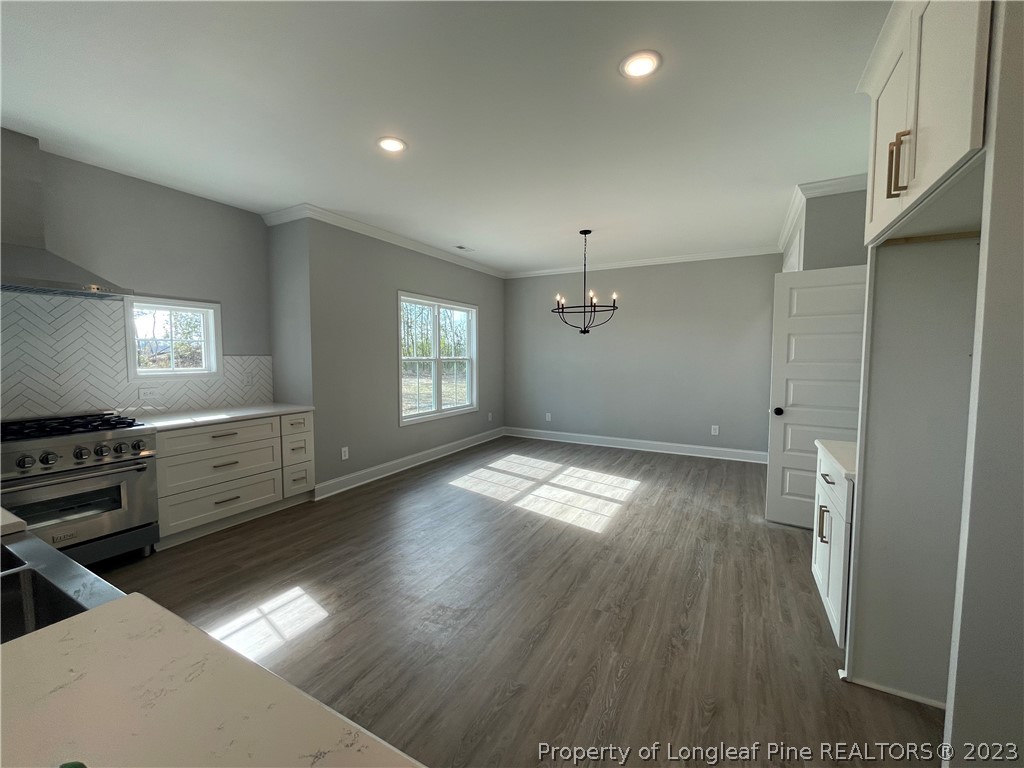 7697 Rufus Johnson Road Fayetteville, NC 28306 - Photo 8 of 16 an empty room with wooden floor and windows