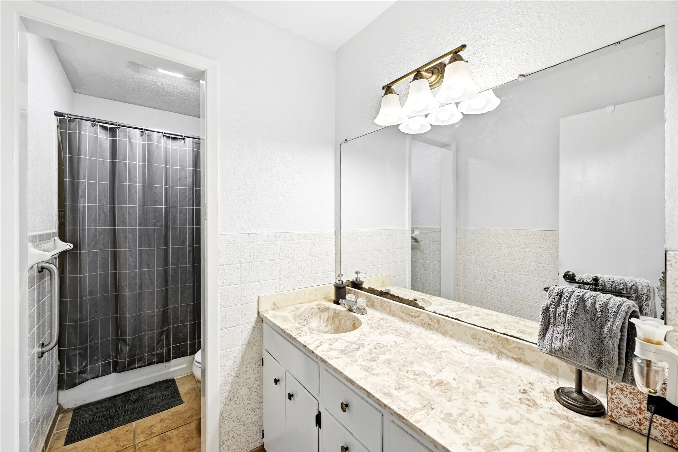 311 Salt Lake Road Luling, TX 78648 - Photo 8 of 37 A spacious vanity with ample counter space anchors this functional split bathroom, and the shower features a safety grab bar.