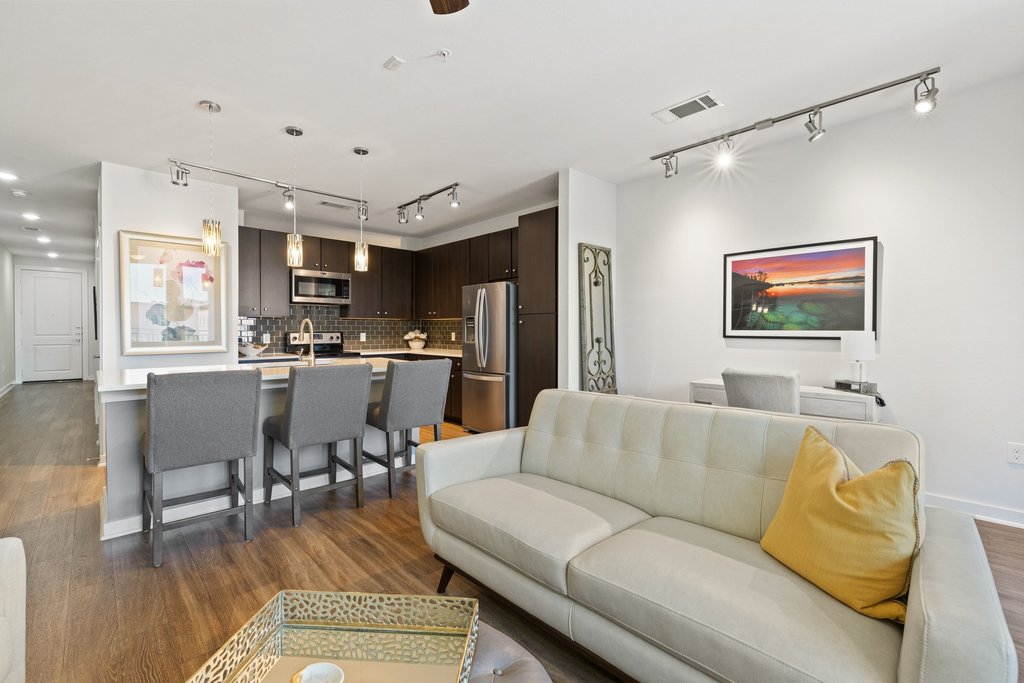 1900 Barton Springs Road, Unit 5009 Austin, TX 78704 - Photo 5 of 35 An open concept living area boasts a modern kitchen island with pendant lighting and stainless steel appliances.