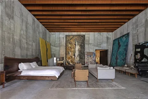 a view of a patio with couches table and chairs under an umbrella