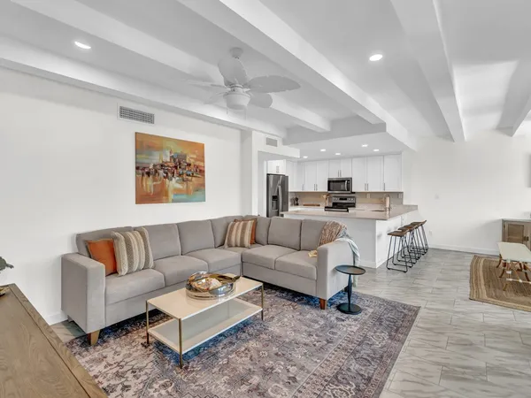 a living room with furniture and kitchen view