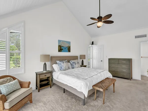 a bedroom with a bed chandelier and a window
