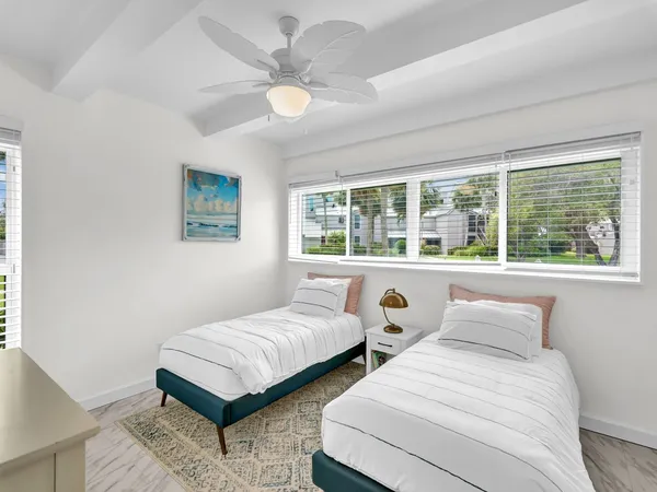 a bedroom with two beds and a large window