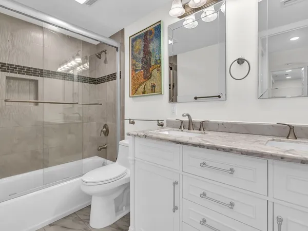 a bathroom with a granite countertop sink toilet and shower
