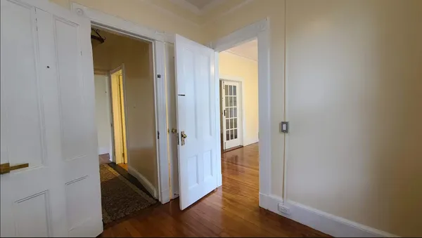 a view of a hallway with wooden floor