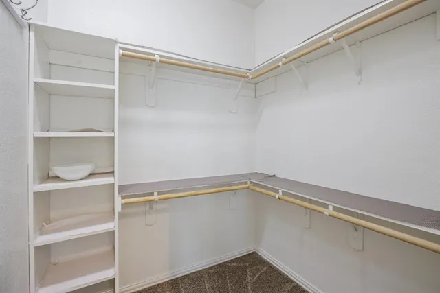 an empty room with windows and ceiling fan