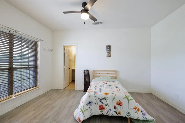 a bathroom with a granite countertop toilet sink shower and mirror