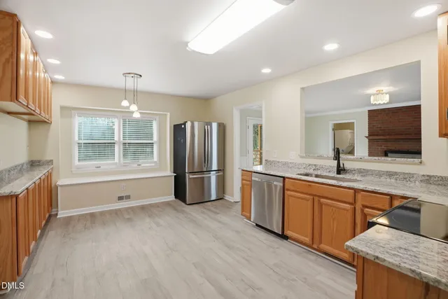 a large kitchen with stainless steel appliances granite countertop a refrigerator and a sink