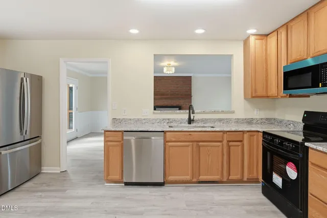 a view of an empty room with a fireplace and a window