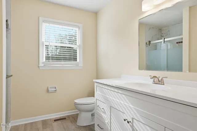 a bathroom with a sink a toilet and a window