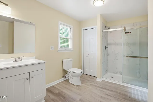 a view of a white house with a large tree