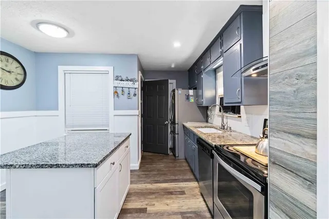 a kitchen with granite countertop stainless steel appliances and wooden cabinets