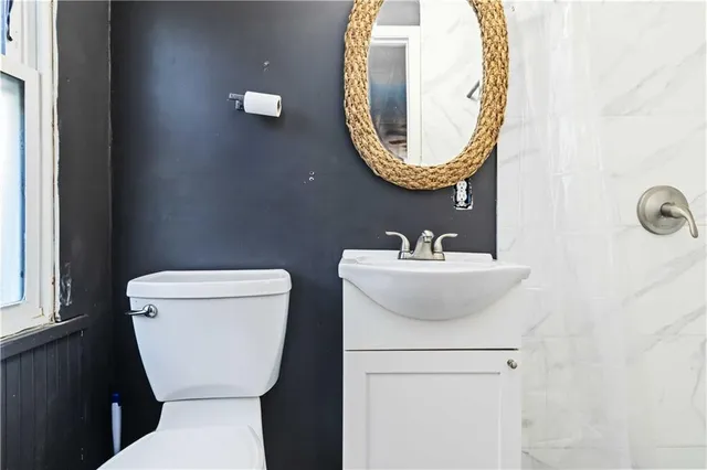 a bathroom with a toilet sink and mirror