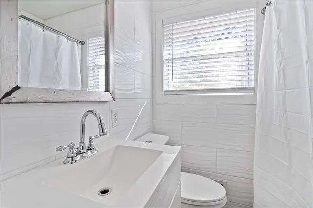 a bathroom with a sink a toilet and a window