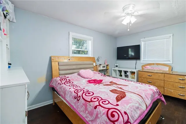 a bedroom with a bed and a flat tv screen on dresser