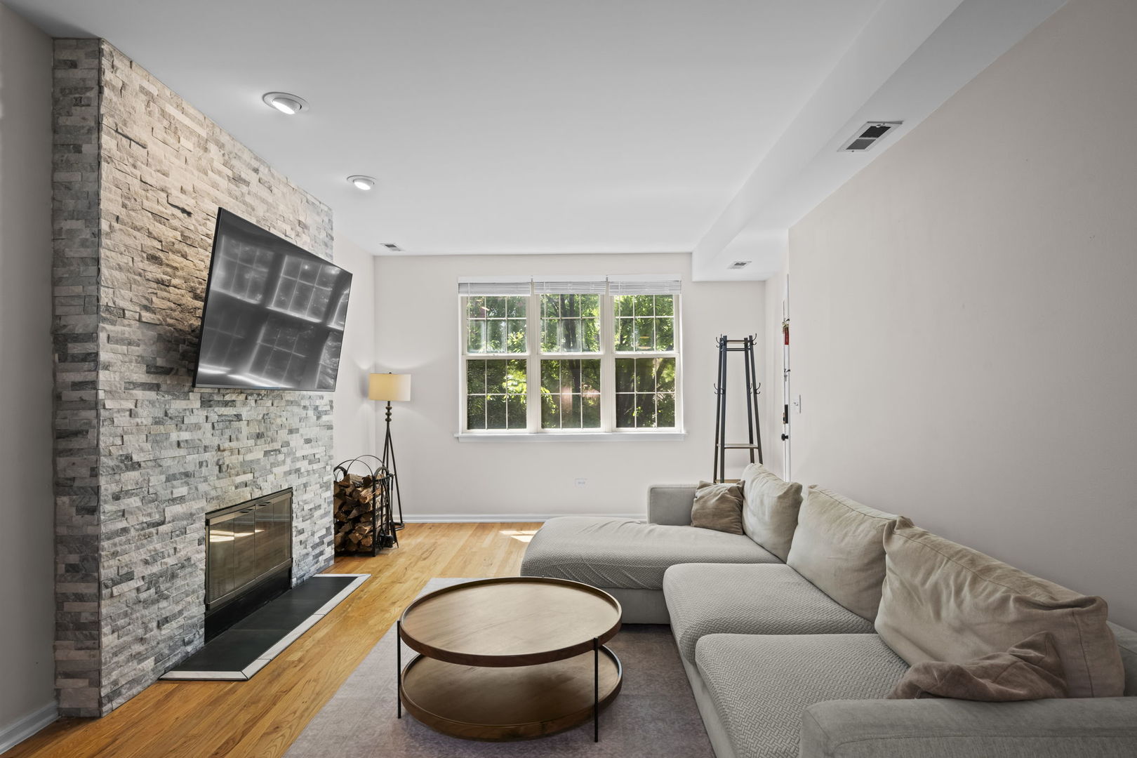 2710 West Haddon Avenue, Unit 2 Chicago, IL 60622 - Photo 3 of 11 a living room with furniture a fireplace and a flat screen tv