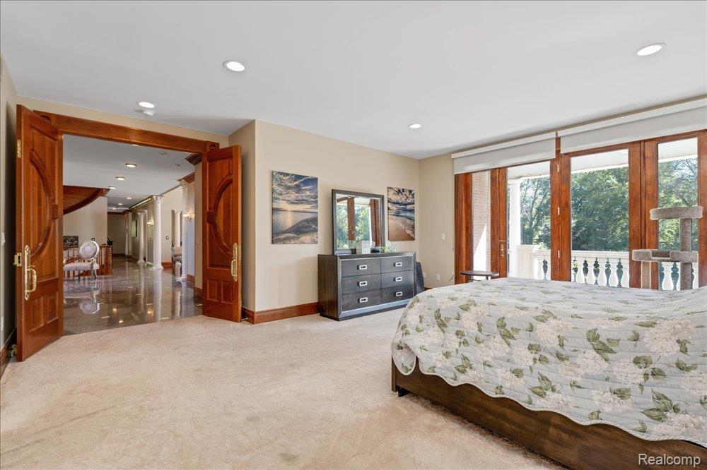 3543 Cedar Brook Drive Rochester, MI 48309 - Photo 62 of 99 Recessed lighting, light-colored carpeting, and wooden double doors with brass hardware, complemented by a balcony featuring a white balustrade
