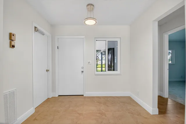 a view of an empty room with window and closet area