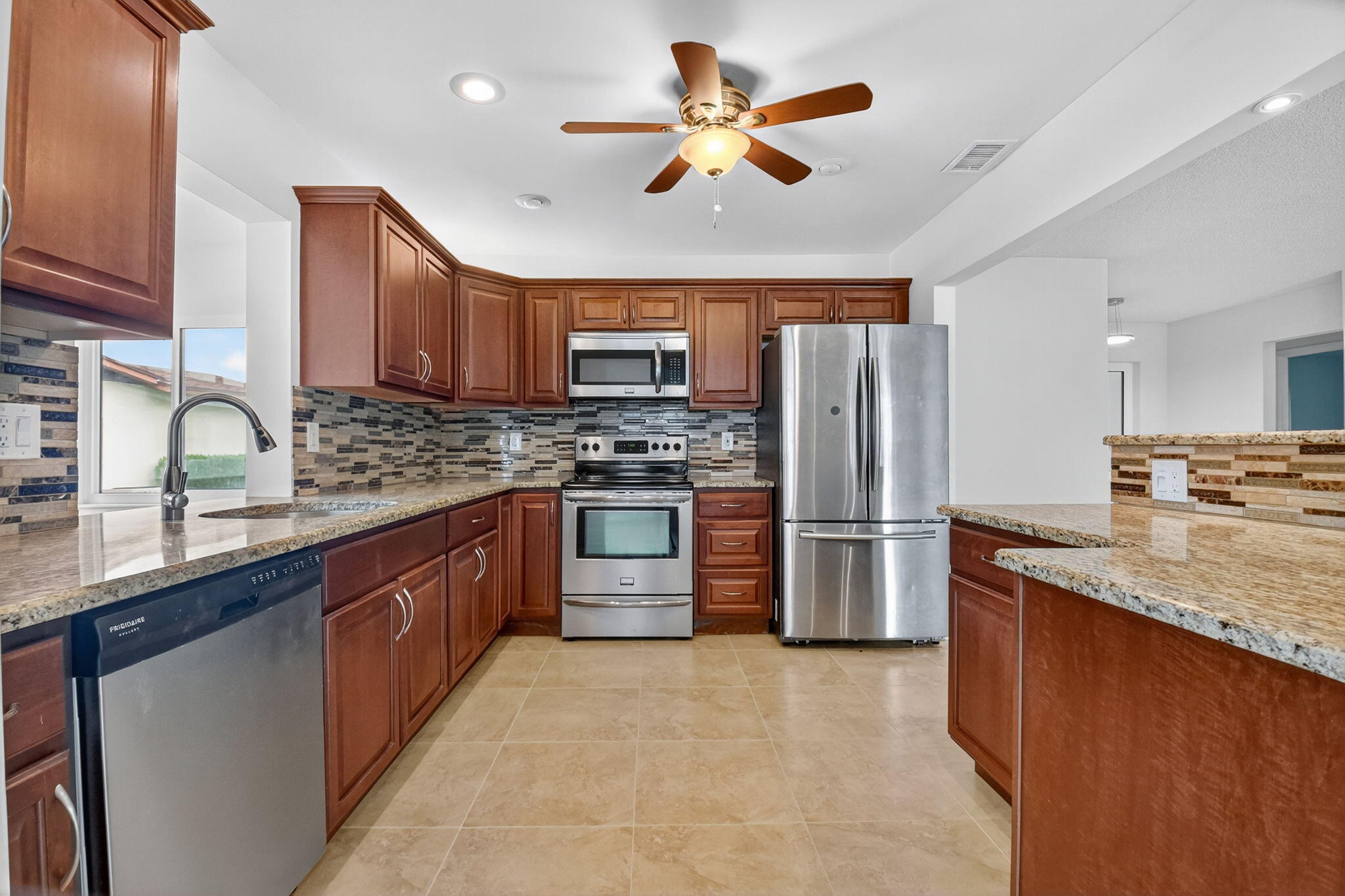 6096 Dusenburg Road Delray Beach, FL 33484 - Photo 5 of 28 a kitchen with stainless steel appliances granite countertop a stove refrigerator sink and dishwasher