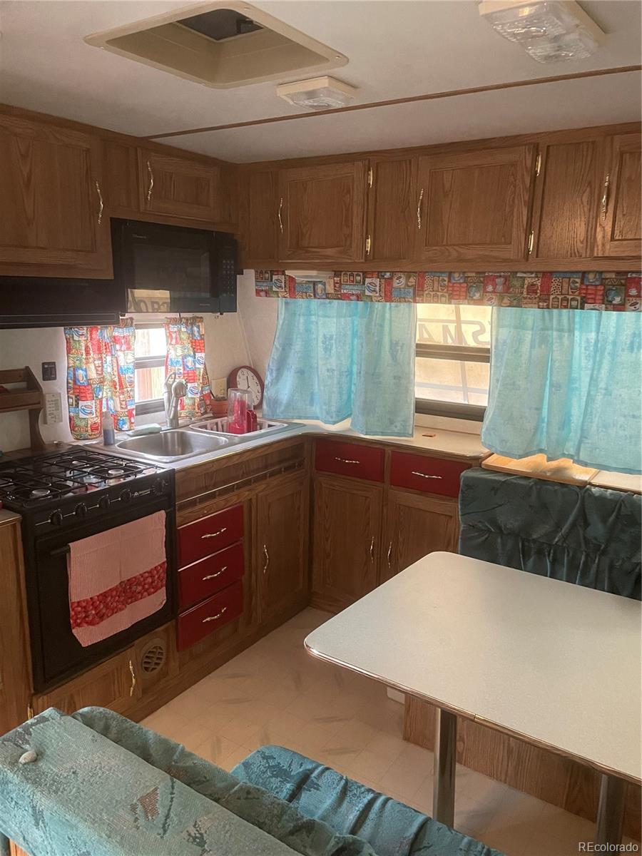 124 Clubcar Road Fairplay, CO 80440 - Photo 8 of 12 a kitchen with stainless steel appliances wooden cabinets a stove and a refrigerator