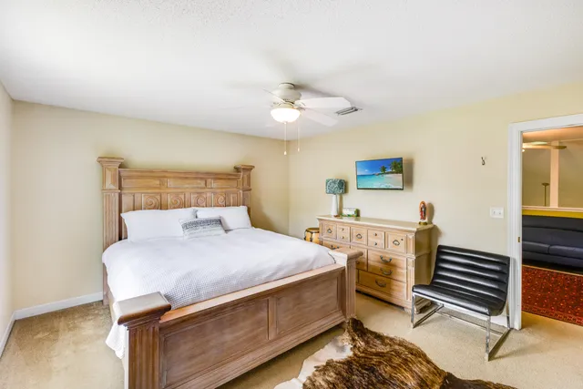 a bedroom with a large bed a chandelier and a window