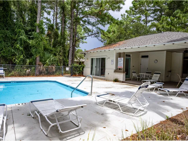 a view of a patio with a table and chairs under an umbrella