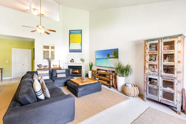 a living room with furniture a fireplace and a large window