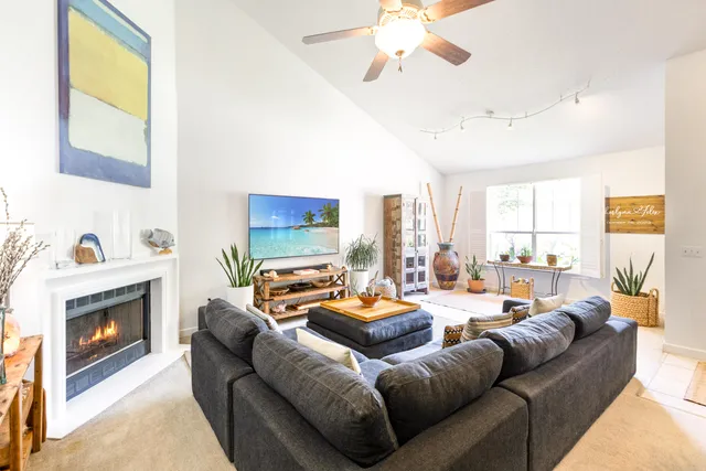 a living room with furniture flat screen tv and a large window