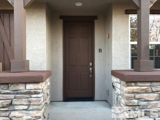 1775 Wind Ranch Road, Unit B Reno, NV 89521 - Photo 2 of 27 a room with a fireplace and large windows