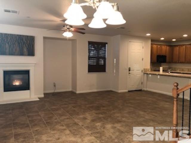 1775 Wind Ranch Road, Unit B Reno, NV 89521 - Photo 6 of 27 a view of an empty room with a fireplace and a chandelier fan