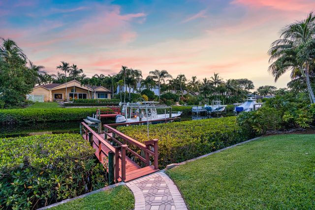 a view of a house with a yard and potted plants