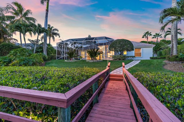 a roof deck with table and chairs potted plants and a large tree