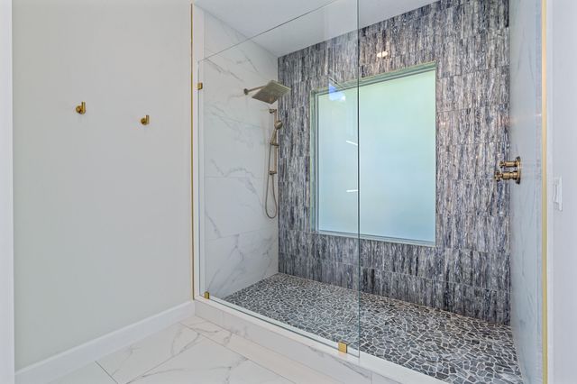 a bathroom with a granite countertop sink a toilet and shower