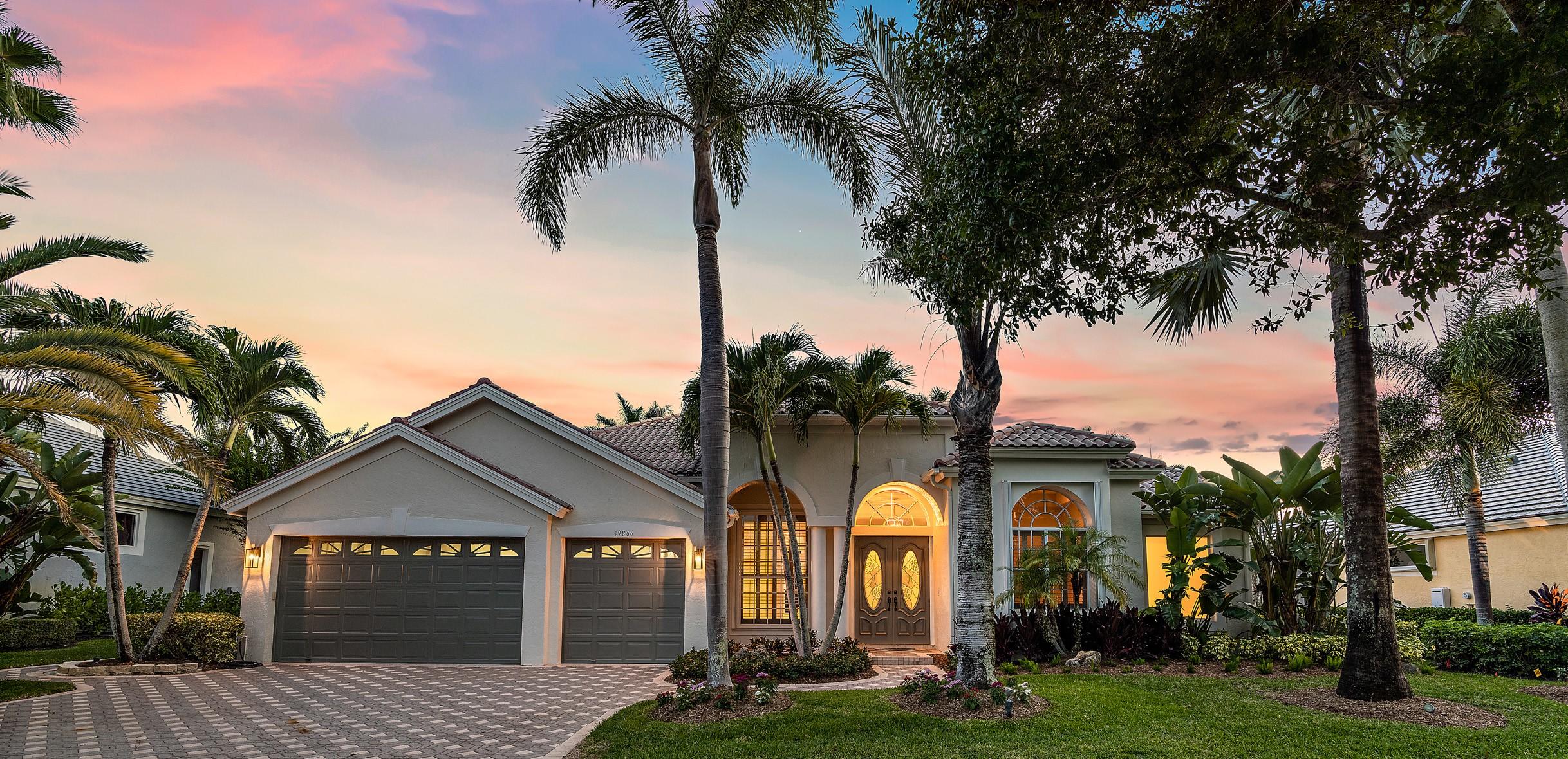 19866 Loxahatchee Pointe Drive Jupiter, FL 33458 - Photo 28 of 43 a front view of a house with a garden and trees
