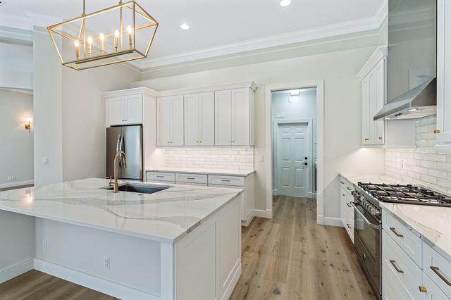 a kitchen with white cabinets and appliances