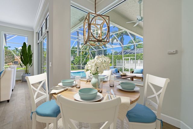 a view of a dining room with furniture a chandelier and wooden floor