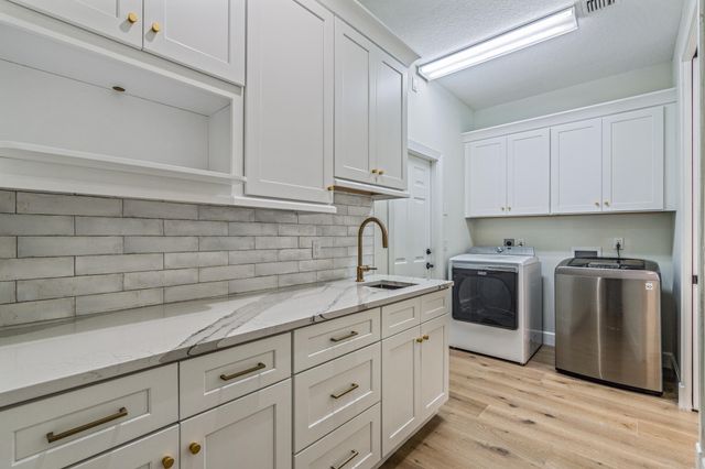 a kitchen with stainless steel appliances granite countertop a sink a stove and cabinets