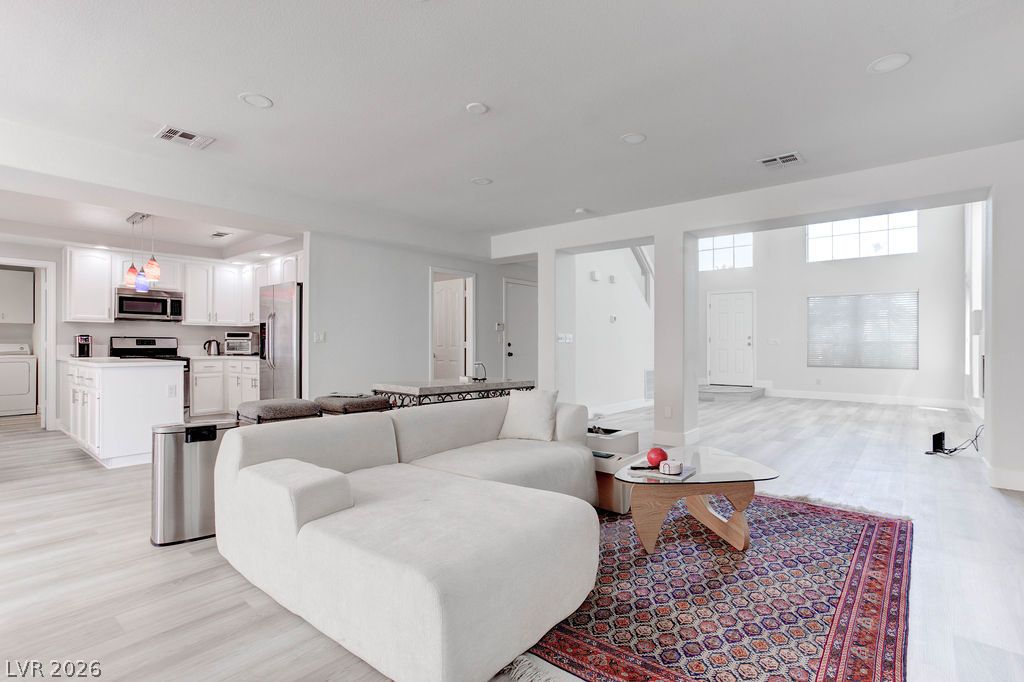 1 Rising Sun Court Henderson, NV 89074 - Photo 47 of 47 An open concept floorplan seamlessly connects the kitchen and living areas, offering effortless movement and abundant natural light.