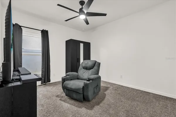 a living room with furniture a ceiling fan and a rug
