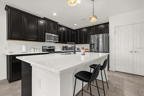 a kitchen with a refrigerator a stove a sink and a cabinets