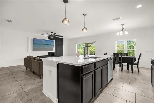 a kitchen with kitchen island a sink counter top space appliances and a window