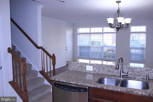 a kitchen with granite countertop a sink a counter top space and cabinets