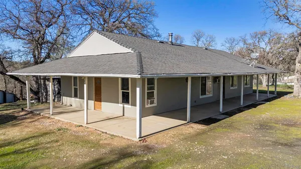 a view of a house with a backyard and floor to ceiling window