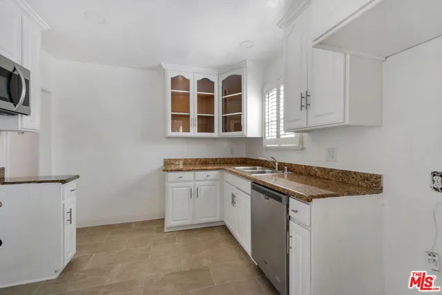 a kitchen with stainless steel appliances granite countertop a sink and a stove top oven