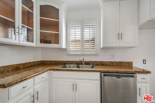 a kitchen with stainless steel appliances granite countertop a sink and a white cabinets