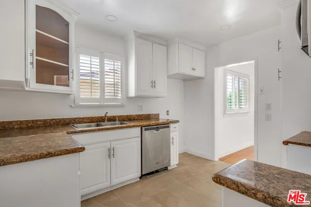 a kitchen with granite countertop a sink stove and cabinets