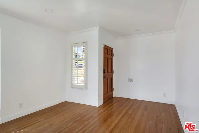an empty room with wooden floor and window