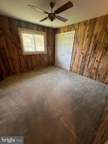 en empty room with windows and ceiling fan