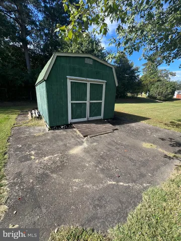 a view of a house with backyard and trees