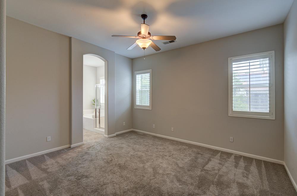 3235 Rall Avenue Clovis, CA 93619 - Photo 19 of 33 an empty room with chandelier fan and windows